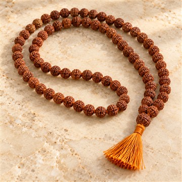 Rudraksha mala arranged on a light stone surface